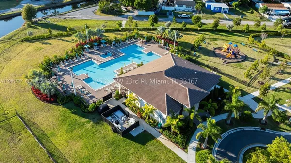 an aerial view of a house with a swimming pool a yard and mountain view in back