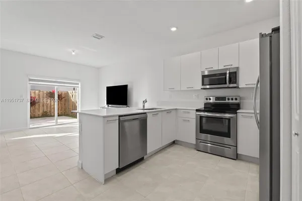 a kitchen with stainless steel appliances a refrigerator sink and microwave