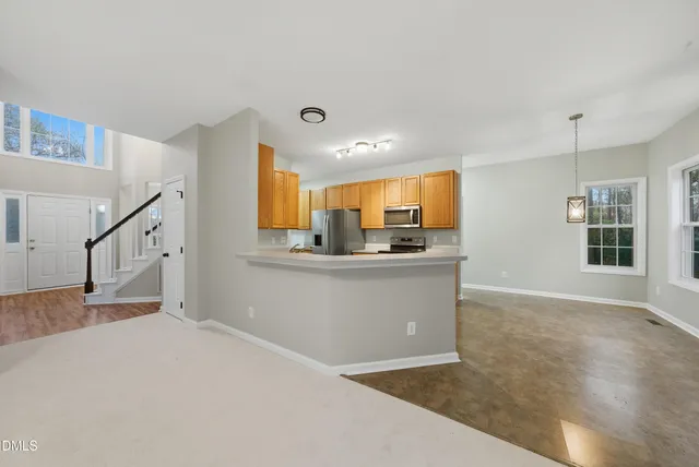 a view of an empty room with a fireplace and a window