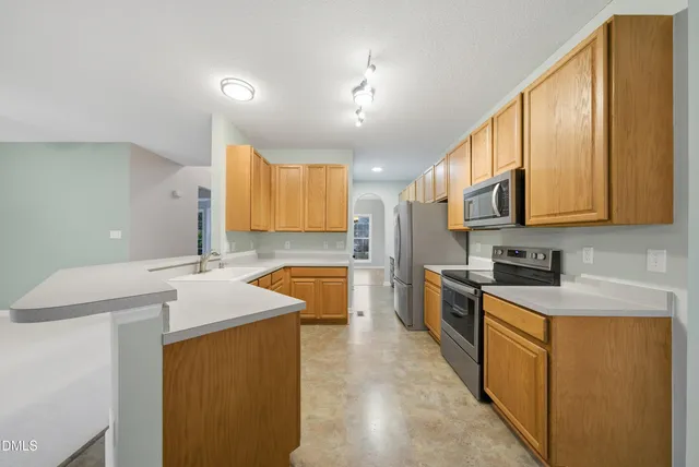 a view of kitchen and hall with wooden floor and windows