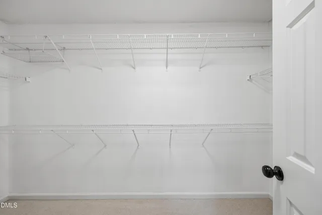 an empty room with window and ceiling fan