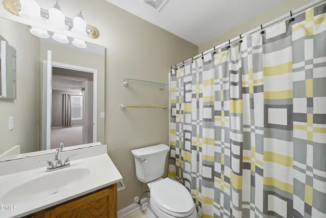 an empty room with a window and ceiling fan