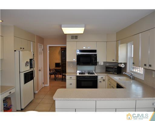 24 Fox Hill Road Edison, NJ 08820 - Photo 5 of 10 a kitchen with a refrigerator and a stove top oven
