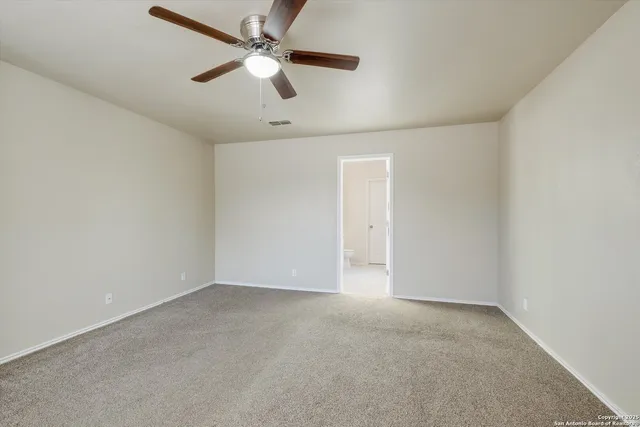 an empty room with a ceiling fan and a fan