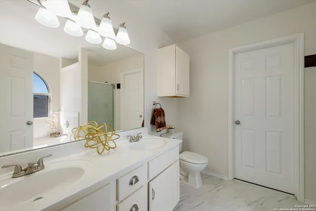 a bathroom with a toilet a sink and a mirror