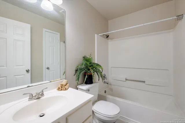 a bathroom with a sink a toilet a mirror and shower