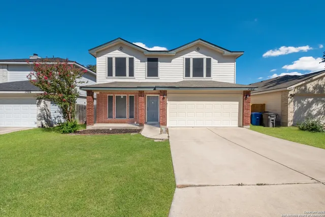 a front view of a house with a garden and yard