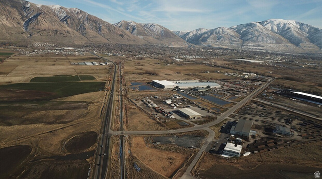1000 Promontory Road Brigham City, UT 84302 - Photo 6 of 13 Expansive aerial landscape featuring a highway, commercial structures, and a residential area with snow-capped mountains in the background
