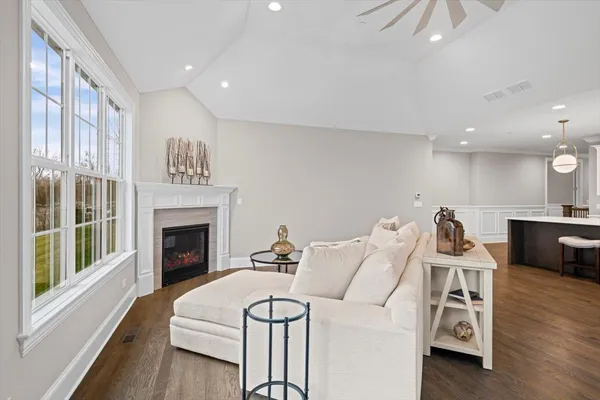 a living room with furniture a fireplace and wooden floor