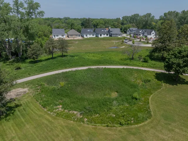 an aerial view of residential houses with outdoor space and trees all around