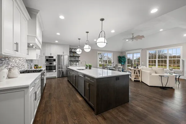 a large kitchen with stainless steel appliances lots of counter space and wooden floor