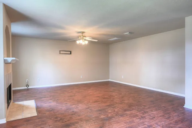 a view of an empty room with a chandelier fan