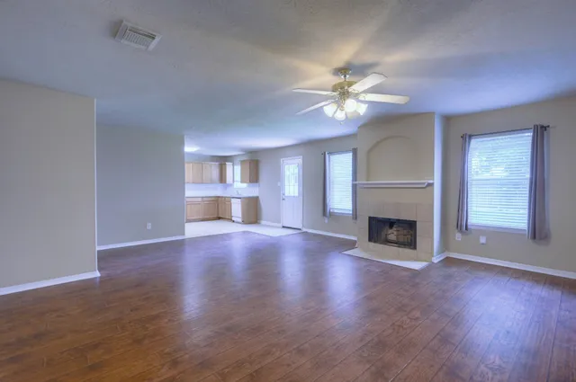 a view of an empty room with a fireplace and a window
