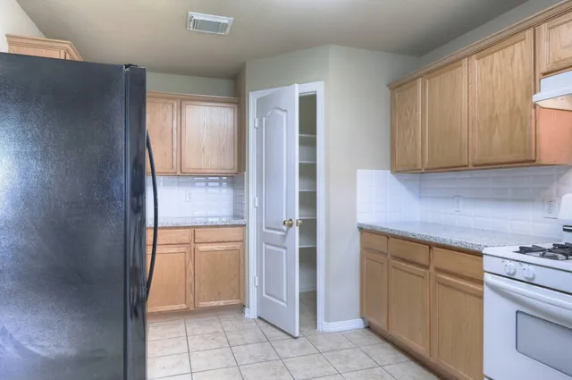 a kitchen with a refrigerator sink and cabinets