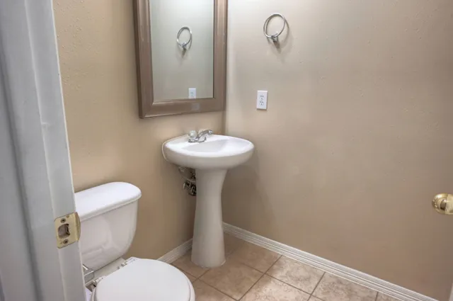 a bathroom with a toilet sink and mirror