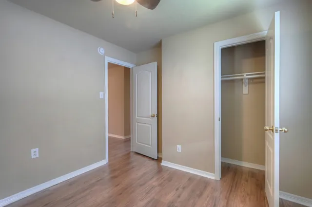 an empty room with wooden floor and closet