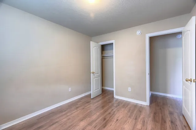 a view of an empty room with wooden floor