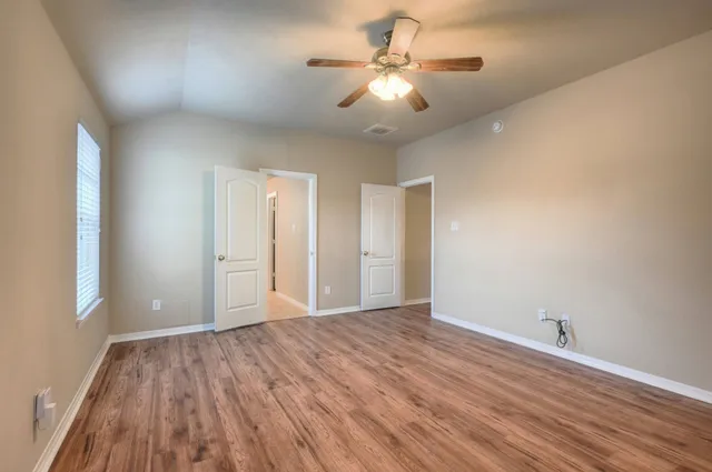 a view of an empty room with wooden floor