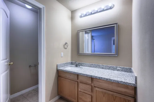 a bathroom with a granite countertop sink and mirror