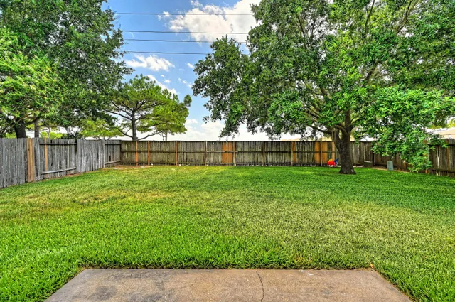 a view of a yard with grass and a fence
