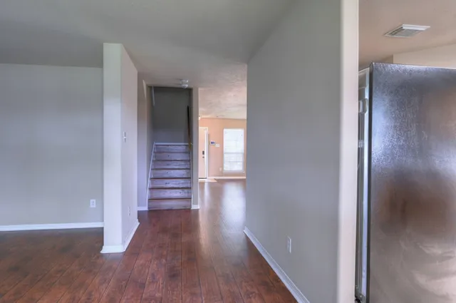 a view of a hallway with wooden floor