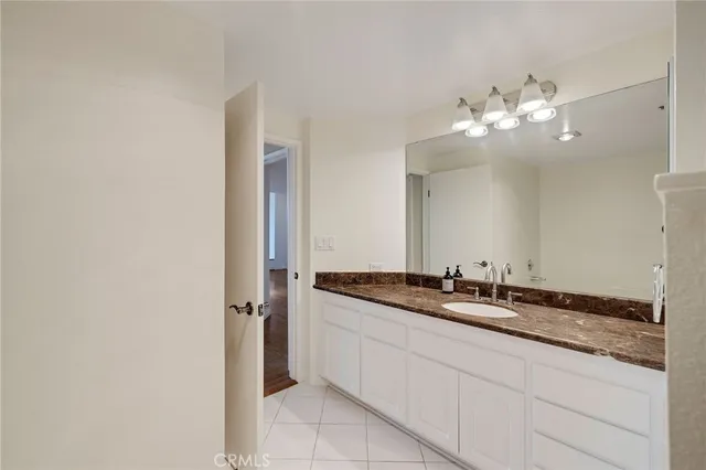 a bathroom with a granite countertop double vanity sink and a mirror