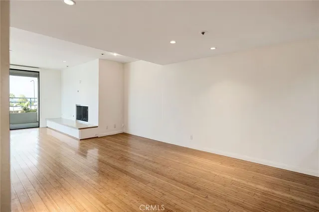 a view of a livingroom with wooden floor and a fireplace