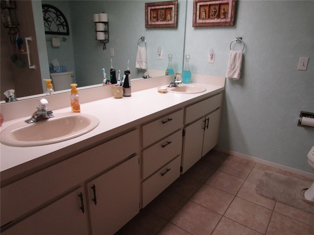 3968 Sailmaker Lane, Unit 3968 Holiday, FL 34691 - Photo 32 of 70 a bathroom with a double vanity sink and a mirror