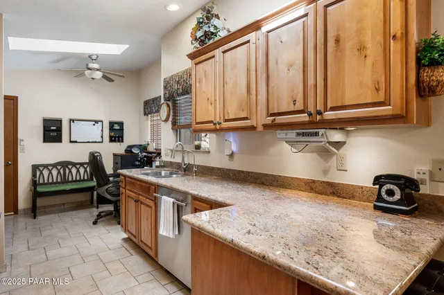 a kitchen with stainless steel appliances granite countertop a sink a stove and a wooden cabinets