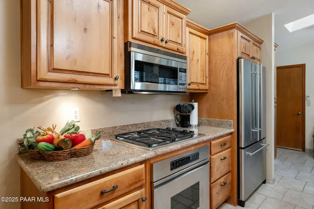 a kitchen with stainless steel appliances granite countertop a stove a refrigerator and a microwave
