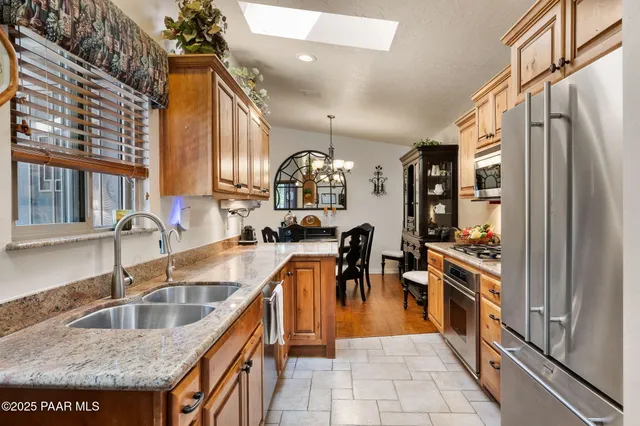 a kitchen with stainless steel appliances granite countertop a sink a stove and a refrigerator