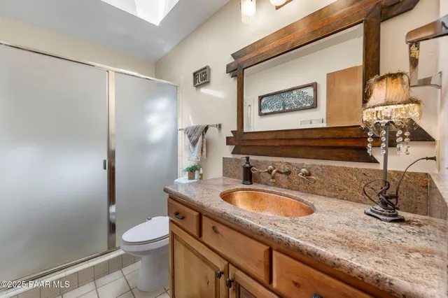 a bathroom with a granite countertop sink a toilet and a mirror