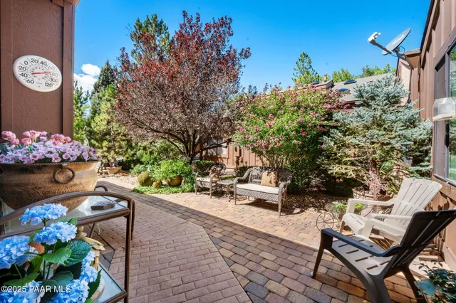 a view of yard with seating area and trees in the background
