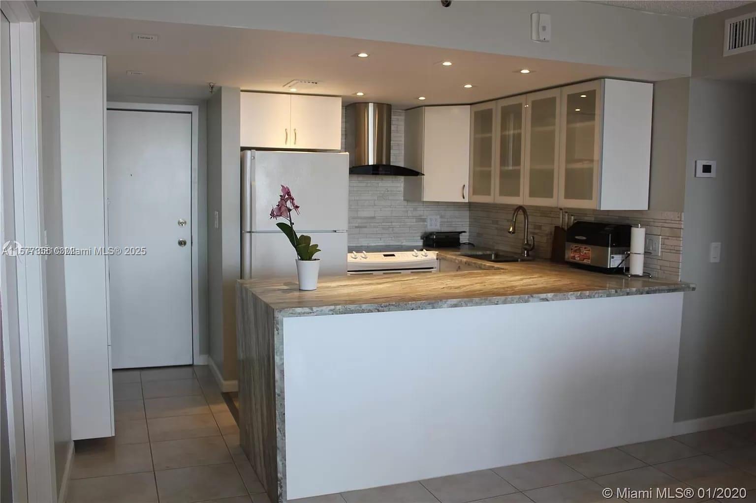 a view of a kitchen with stainless steel appliances granite countertop a sink and a refrigerator