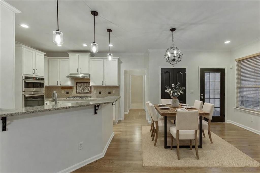 1830 Sanborne Way Dacula, GA 30019 - Photo 6 of 33 a view of a dining room and livingroom with furniture wooden floor a chandelier