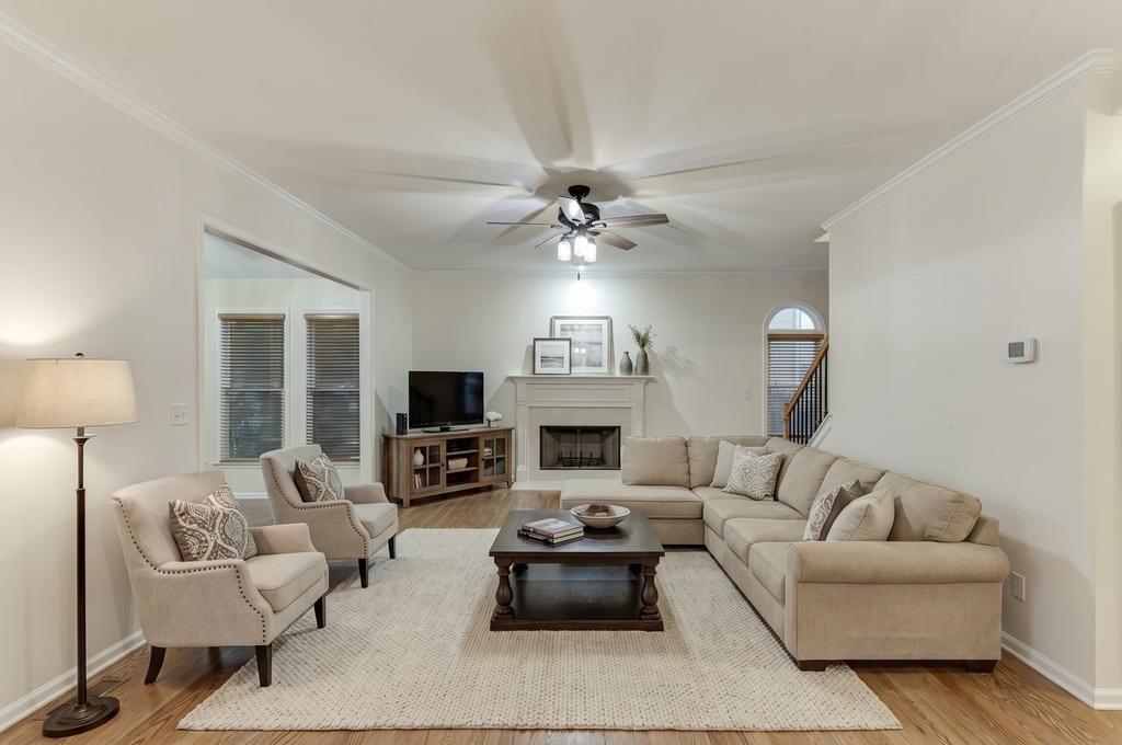 1830 Sanborne Way Dacula, GA 30019 - Photo 7 of 33 a living room with furniture a fireplace and a chandelier