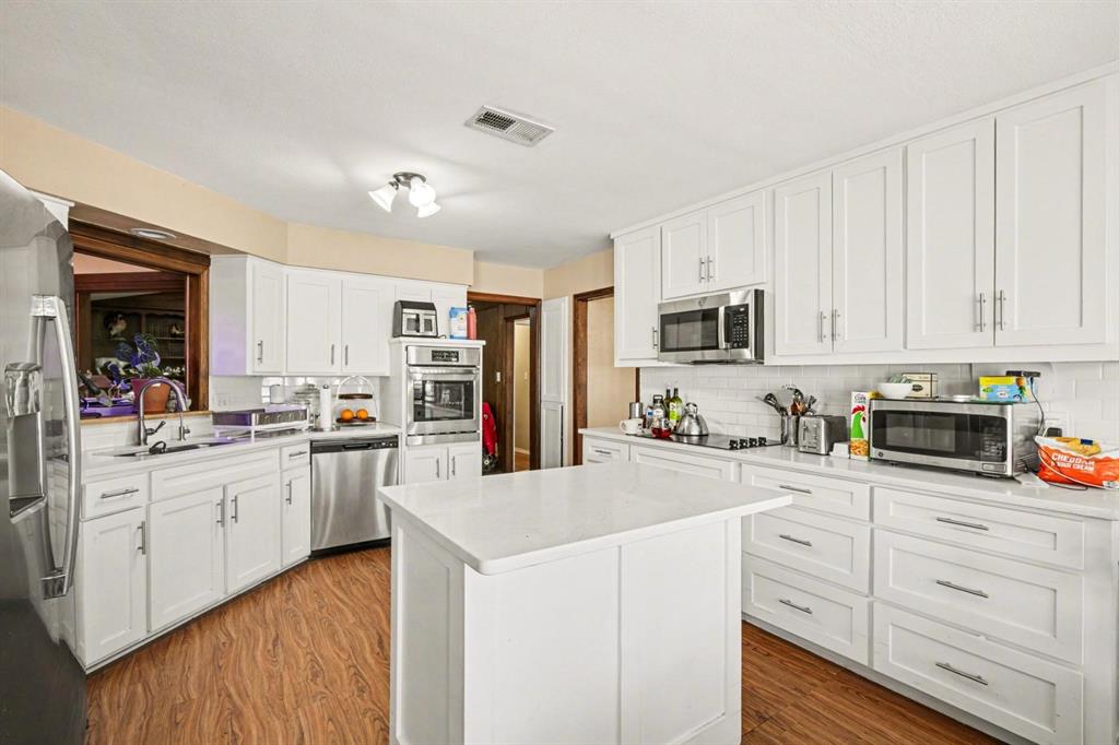 5009 River Ridge Road Arlington, TX 76017 - Photo 11 of 28 a kitchen with granite countertop white cabinets and white appliances