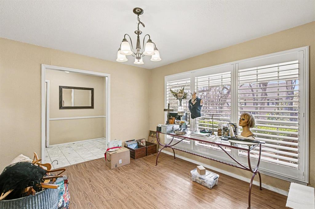 5009 River Ridge Road Arlington, TX 76017 - Photo 16 of 28 a bedroom with furniture and a chandelier