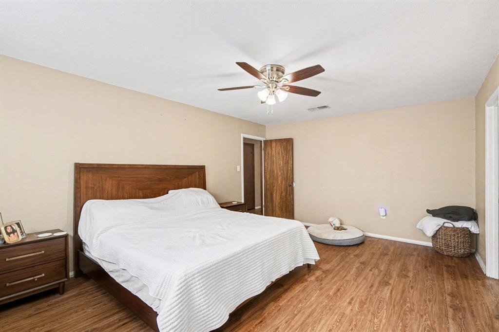 5009 River Ridge Road Arlington, TX 76017 - Photo 18 of 28 a bedroom with a bed and a chandelier