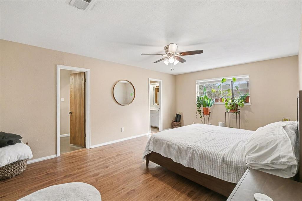 5009 River Ridge Road Arlington, TX 76017 - Photo 19 of 28 a bedroom with a bed and a chandelier