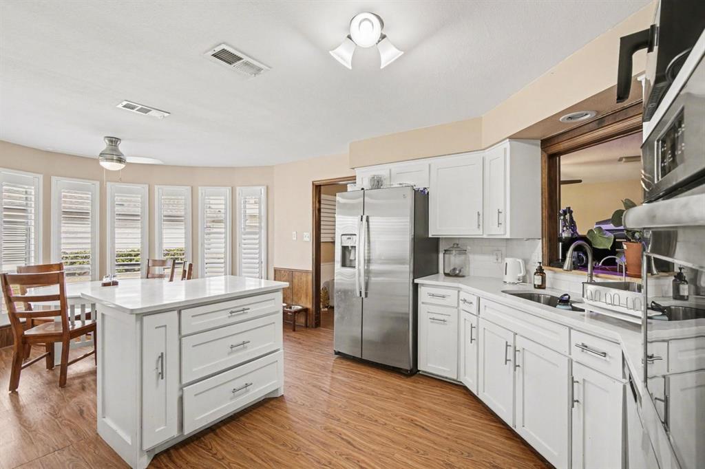 5009 River Ridge Road Arlington, TX 76017 - Photo 9 of 28 a kitchen with kitchen island white cabinets and stainless steel appliances
