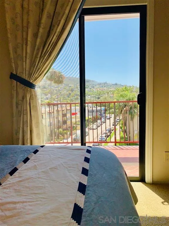 2130 Vallecitos, Unit 441 La Jolla, CA 92037 - Photo 17 of 25 a bedroom with a bed and glass door