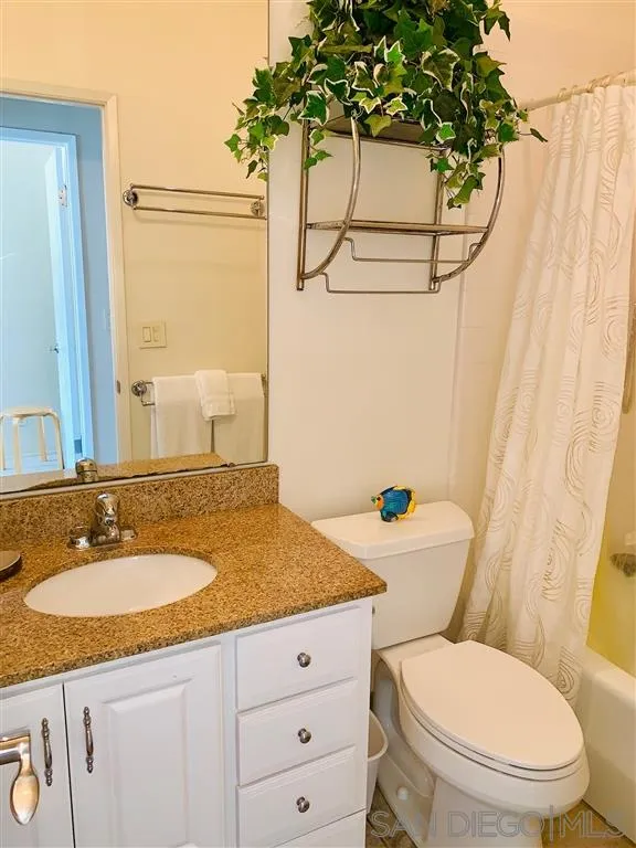 2130 Vallecitos, Unit 441 La Jolla, CA 92037 - Photo 18 of 25 a bathroom with a granite countertop toilet sink and mirror