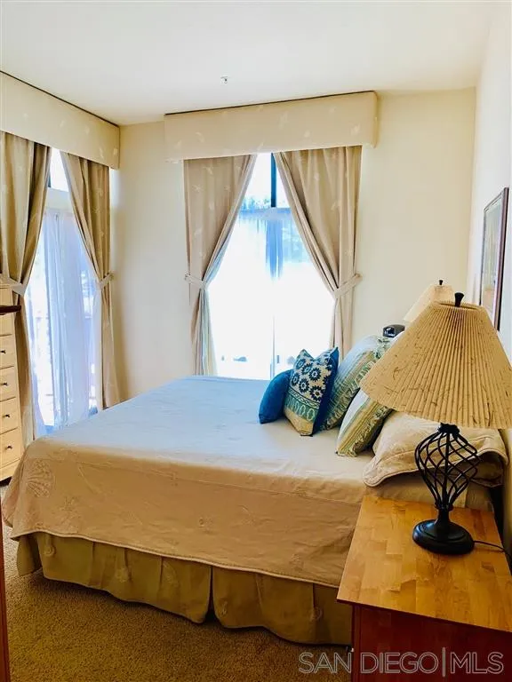 2130 Vallecitos, Unit 441 La Jolla, CA 92037 - Photo 19 of 25 a bedroom with a bed and a chandelier