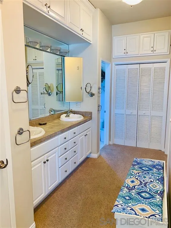 2130 Vallecitos, Unit 441 La Jolla, CA 92037 - Photo 22 of 25 a spacious bathroom with a granite countertop sink a mirror a vanity and a shower