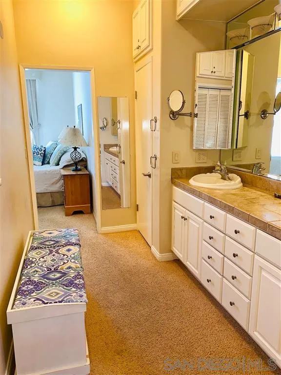 2130 Vallecitos, Unit 441 La Jolla, CA 92037 - Photo 23 of 25 a spacious bathroom with a double vanity sink and a mirror