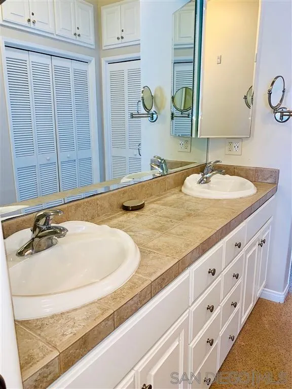 2130 Vallecitos, Unit 441 La Jolla, CA 92037 - Photo 25 of 25 a bathroom with a granite countertop sink and a mirror