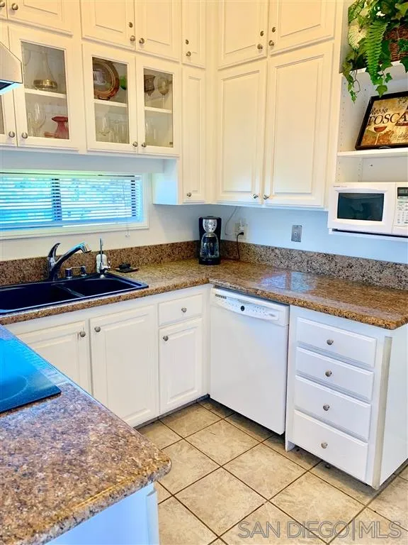 2130 Vallecitos, Unit 441 La Jolla, CA 92037 - Photo 5 of 25 a kitchen with granite countertop white cabinets and white appliances