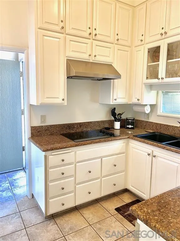 2130 Vallecitos, Unit 441 La Jolla, CA 92037 - Photo 6 of 25 a kitchen with granite countertop a sink and cabinets