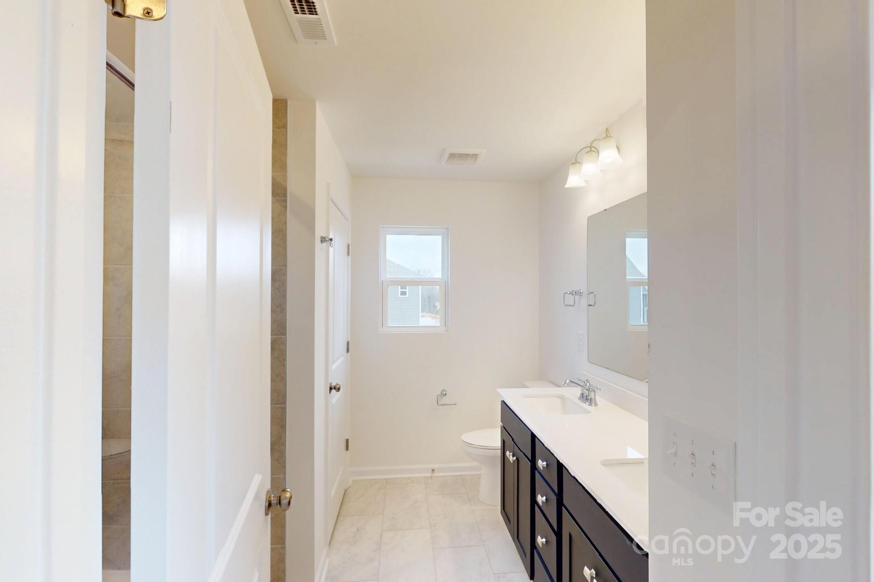 1030 Overbrook Place Wingate, NC 28174 - Photo 20 of 21 a bathroom with a double vanity sink and a mirror